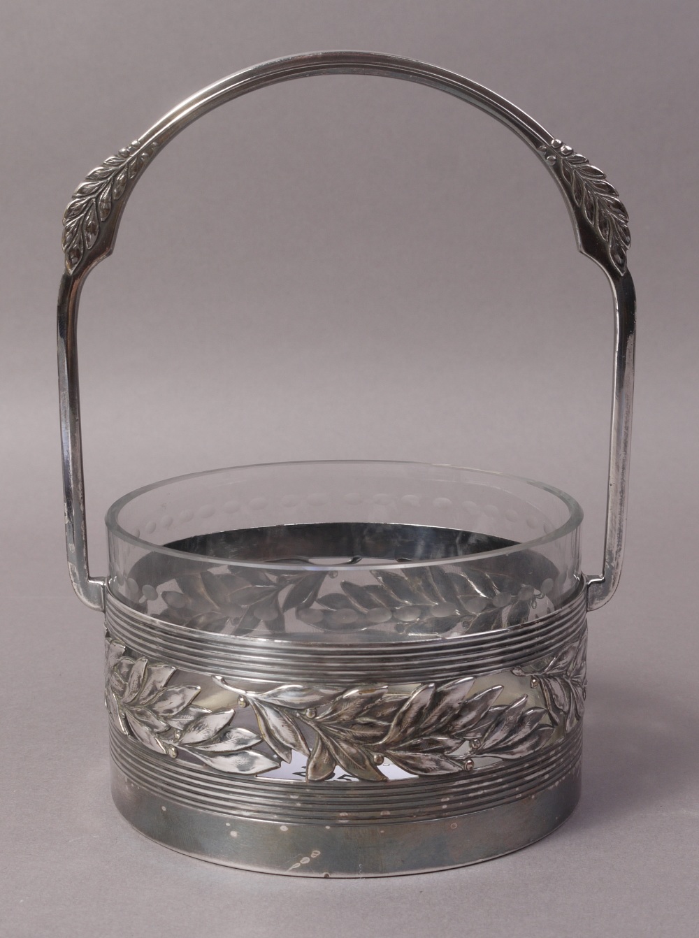 A WMF CIRCULAR PRESERVE BASKET with clear glass liner, pierced laurel leaf,