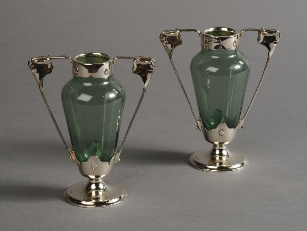 A PAIR OF ART NOUVEAU IRIDESCENT GREEN GLASS AND SILVER MOUNTED TWO HANDLED VASES,