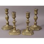 A PAIR OF MID 18TH CENTURY BRASS CANDLESTICKS with waisted sconces and baluster knopped stems,