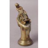 A LATE VICTORIAN GILDED BRONZE DESK SEAL OR STAND, modelled as a girl on a wooden sledge,