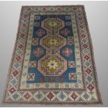 A TURKISH WOOL CARPET, 20th century, with three main geometric lozenges, on a blue ground,