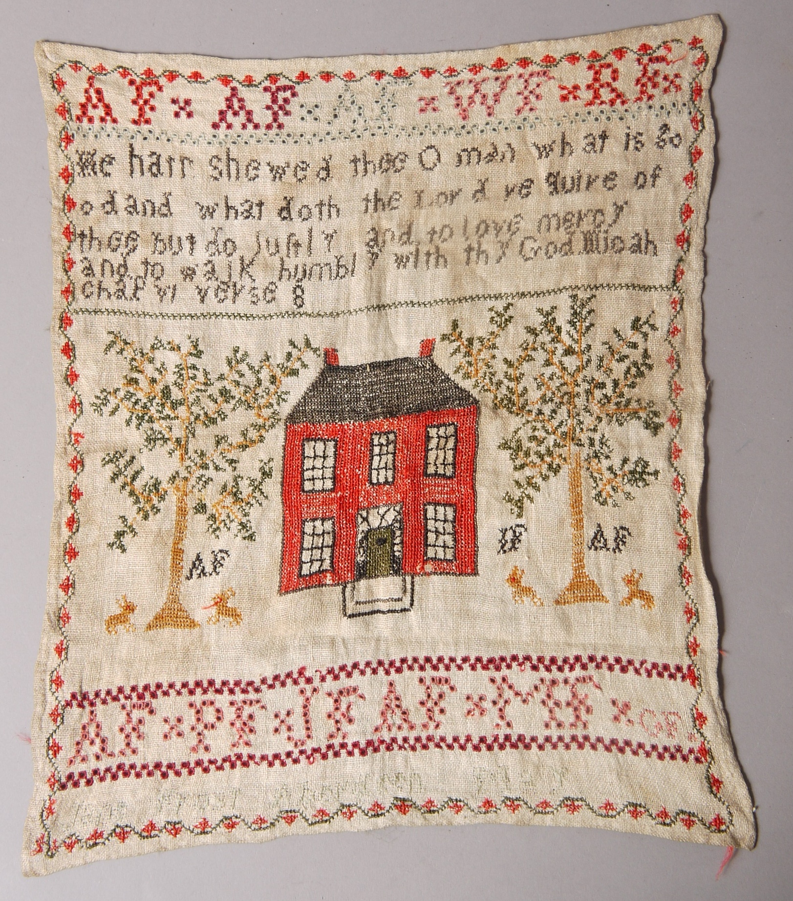 A 19TH CENTURY NEEDLEWORK SAMPLER worked with a red house flanked by trees and rabbits,