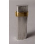 A CIGARETTE LIGHTER BY CHRISTIAN DIOR, in white metal and gold plated ribbed case,