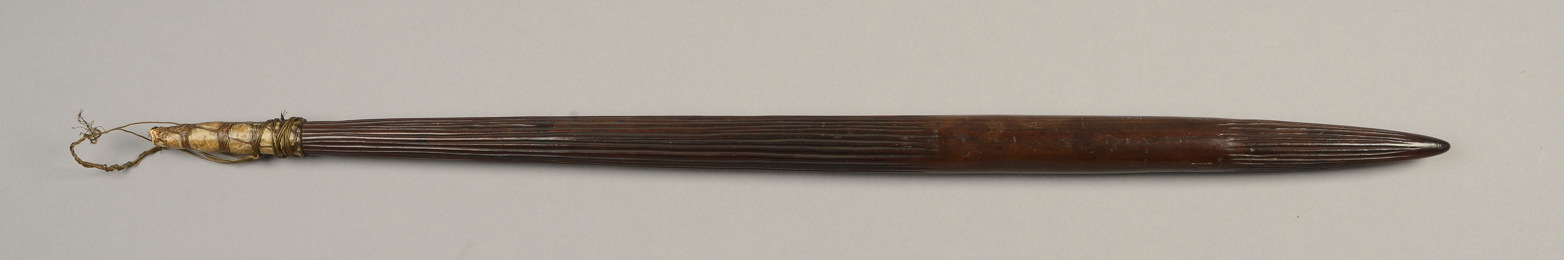 A 19TH CENTURY AFRICAN HARDWOOD THROWING CLUB of ribbed tapered form, figured with good patination,