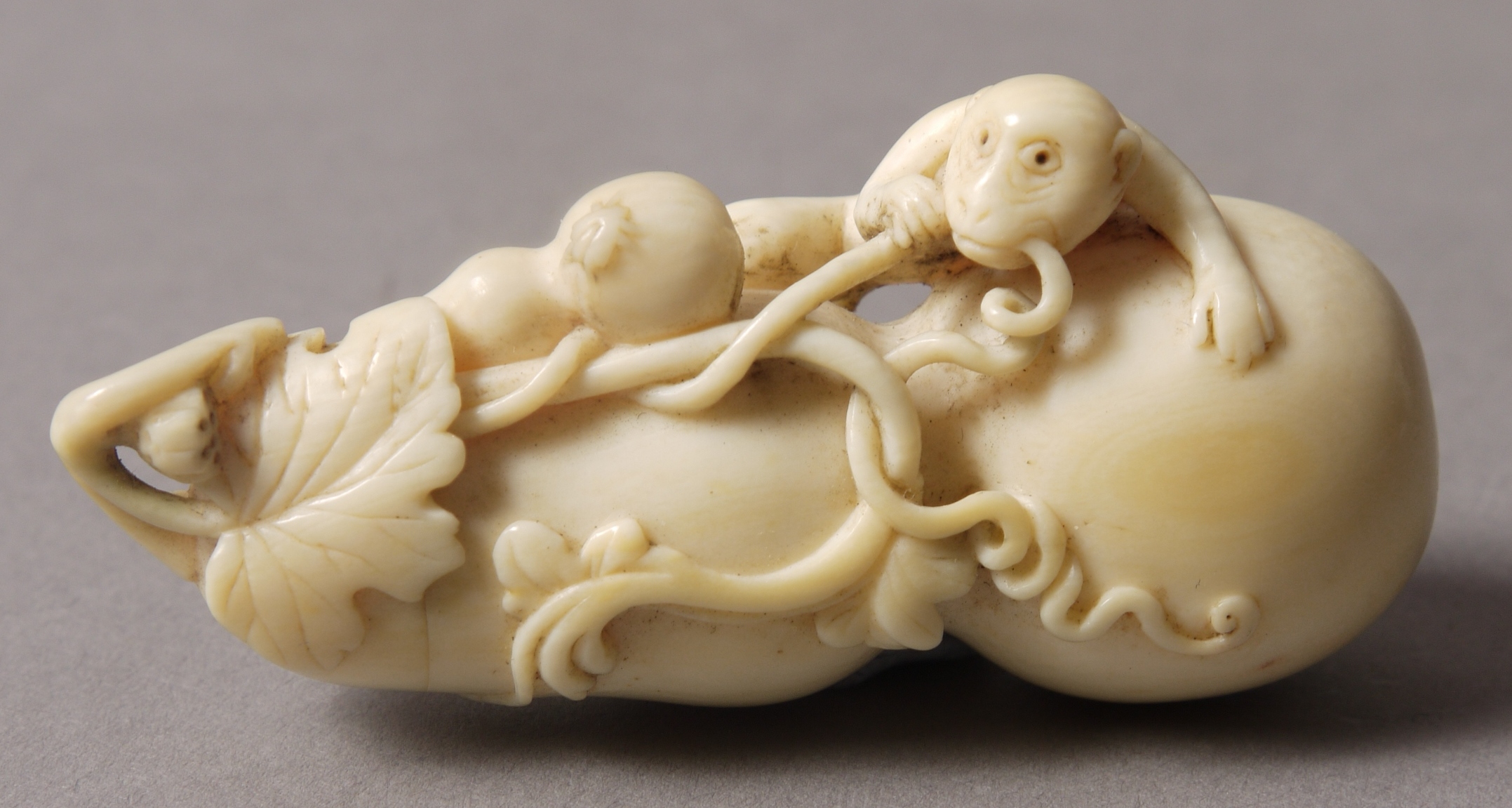 A 19TH CENTURY CHINESE IVORY DOUBLE GOURD BOTTLE, carved with a monkey, vine and gourd,