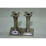 A Pair Of Square Based Corinthian Column Weighted Silver Candle Sticks, 6" High