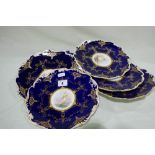 A Set Of Six Coalport Deep Blue And Gilt Ground Dessert Plates Each With Centre Painted Sailboat