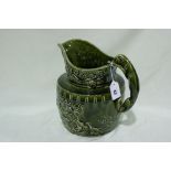A Green Glazed Moulded Pottery Water Jug With Greyhound Handle