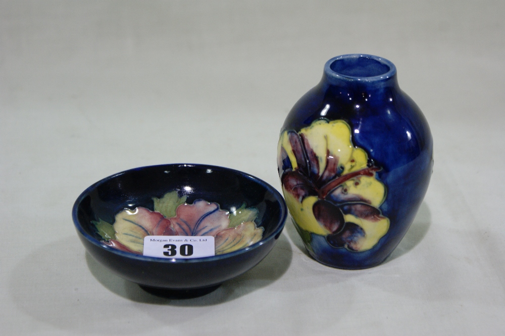 A Moorcroft Pottery Deep Blue Ground And Floral Decorated Miniature Vase And Circular Bowl, The Vase