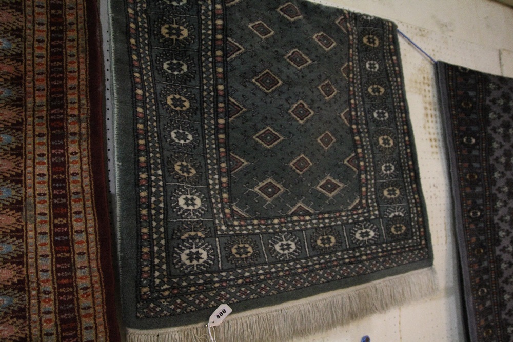 A Green Ground Rug With Successive Borders And Tassel Edge