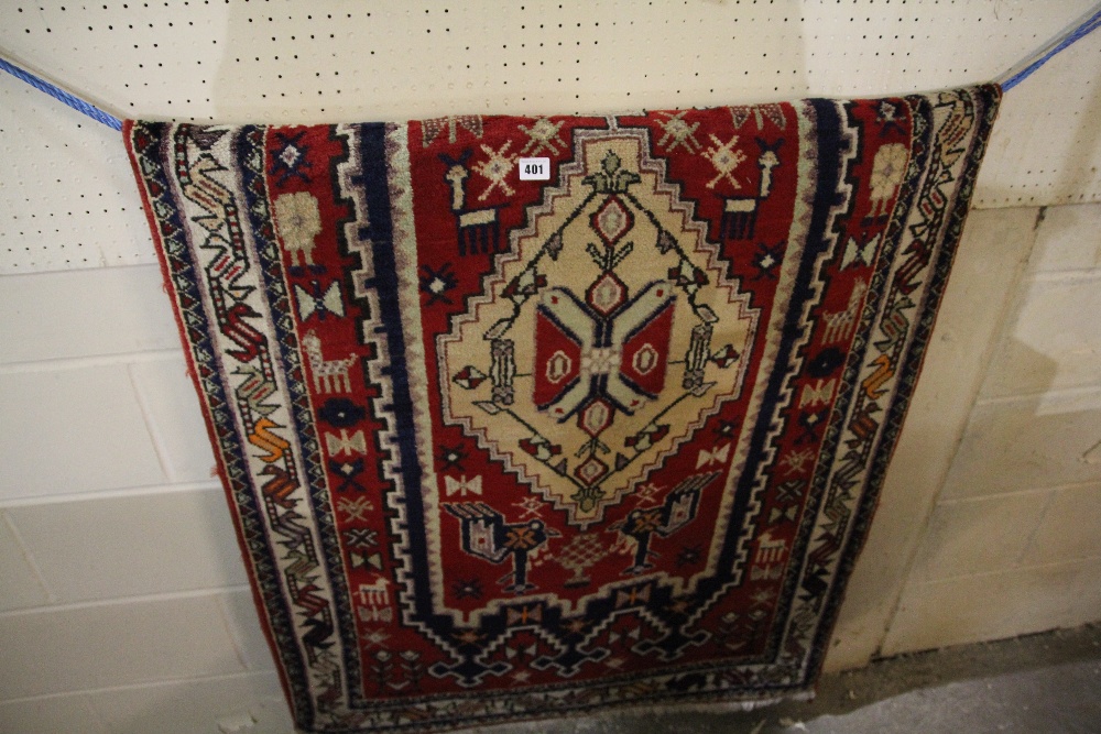 An Iranian Red Ground Woollen Rug With Stylised Motifs