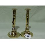A Pair Of Circular Based Antique Brass Candle Holders With Side Push Button Action
