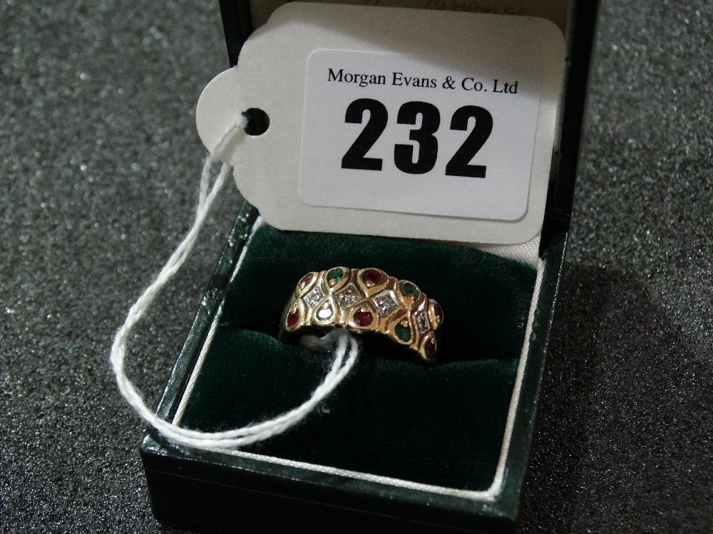 A Gold Ring Set With Diamond, Garnet And Emerald