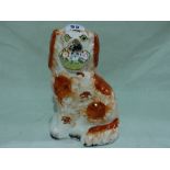 A Staffordshire Pottery Red And White Decorated Seated Dog With Basket Of Flowers