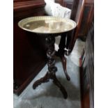 A Circular Brass Topped Black Forest Carved Pedestal Stand