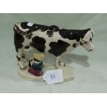 A Staffordshire Pottery Black And White Decorated Cow Creamer And Milk Maid