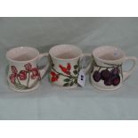 Three Cream Ground Moorcroft Pottery Mugs