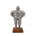 MICHELIN: A Bibendum statuette in aluminium on a wooden base; 33cms tall (including base).