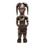 A West African carved wooden tribal figure, 20th century  A West African carved wooden tribal