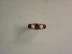 An Edwardian 9ct Gold Ring Set with three garnets and two opals.