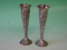 A Pair of Indian Silver Bud Vases Of tapered form, embossed with animals, buildings and fish in