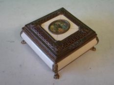 A French Jewellery Casket Gilt metal and faux ivory, the lid with inset vignette of a garden scene