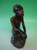 An African Carved Hardwood Figure A seated man. Inscribed on base. Congolese. 20th century. 12 ½"