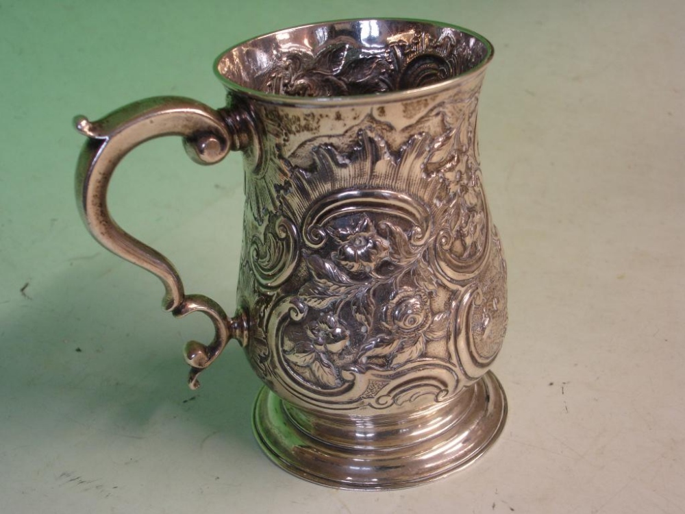 An Early George 111 Silver Mug Profusely embossed and chased with C scrolls, rockwork, vine fruits