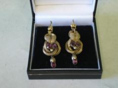 A Pair of Victorian Gold Earrings Of entwined loop and vine leaf form, each set with three