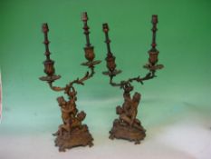 A Pair of Bronze Two Light Candelabra The acanthus scrolled branches supported by a pair of putto