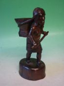 An Ethnic Carved Hardwood Figure A woman with a basket on her back and carrying a club. 11" high