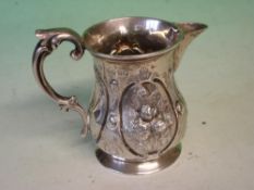 A Victorian Silver Cream Jug Embossed with flower sprays in reserves, double scroll handle. London