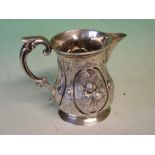A Victorian Silver Cream Jug Embossed with flower sprays in reserves, double scroll handle. London