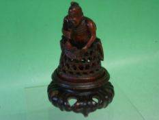 A Japanese Carved Treen Figure A fisherman with fish and basket, raised on a lotus carved hardwood