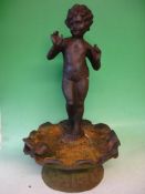 Garden Statuary A cast iron putto, standing on a seashell with a dove. 24" high