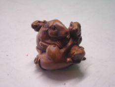 A Japanese Wood Netsuke carved as a group of five mice. Signed. (One glass eye lacking)