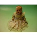 A German Baby Doll. The porcelain head with sleeping eyes and open mouth, composition body and