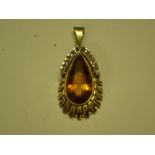 A Modernist Pendant in 14ct gold, set with a large pear shaped topaz and surmounted by thirteen