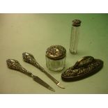 A Silver Manicure Set together with a silver topped scent bottle and a silver topped jar.