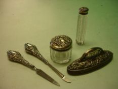 A Silver Manicure Set together with a silver topped scent bottle and a silver topped jar.
