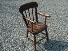 Child's Country Armchair. The elm seat with round cut out and cover, raised on ring turned splayed