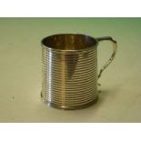 A Silver Mug. The slightly tapered body with reeded bands, oval cartouche engraved "Betty." 2 ¾"