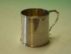 A Silver Mug. The slightly tapered body with reeded bands, oval cartouche engraved "Betty." 2 ¾"