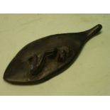 African Art. An ebony pendant of oval form, carved with a kneeling figure. 3 ½" long