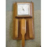 An Oak Aneroid Barometer. Shortland Smiths. Fitted with three clothes brushes. 15" high