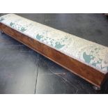 A Victorian Walnut Footstool of sarcophagus form with upholstered top raised on bun feet. 41 ½"