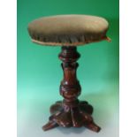 A Victorian Walnut Piano Stool. The screw adjusting over-stuffed seat raised on a lappet moulded