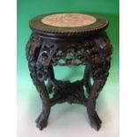 A Chinese Hardwood Stand. The beaded pink marble inset top above a carved and pierced apron of birds