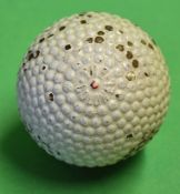 Red dot 'The Colonel' bramble pattern rubber core golf ball with the patent number to the opposite