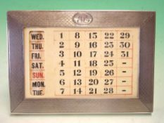 A Silver Desk Calendar The engine turned frame with initialled cartouche, enclosing the celluloid